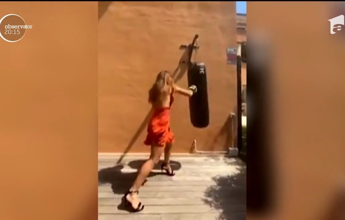 O blonda pe tocuri rupe sacul de box cu pumnii şi picioarele