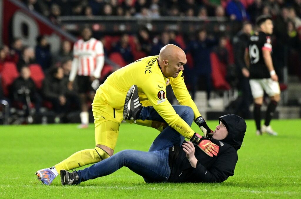Scene șocante în PSV – Sevilla! Portarul oaspeților a pus la pământ un fan care a încercat să-l atace